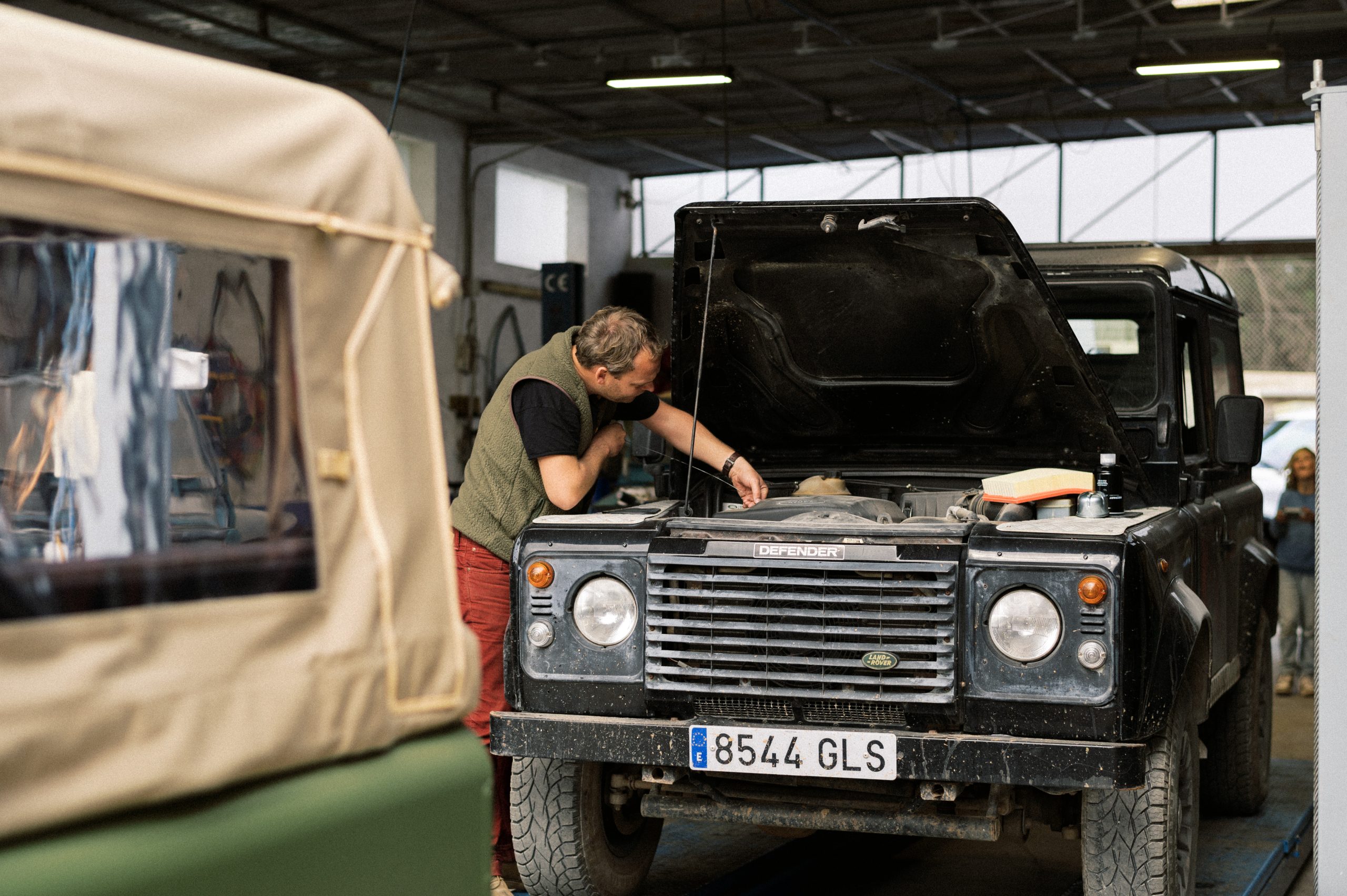 Mechanic inspecting a classic Land Rover Defender in the Ibiza Defenders workshop